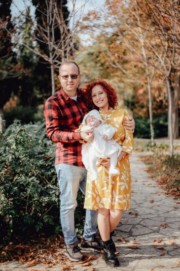 Family enjoying a sunny autumn day outdoors, smiling and embracing.